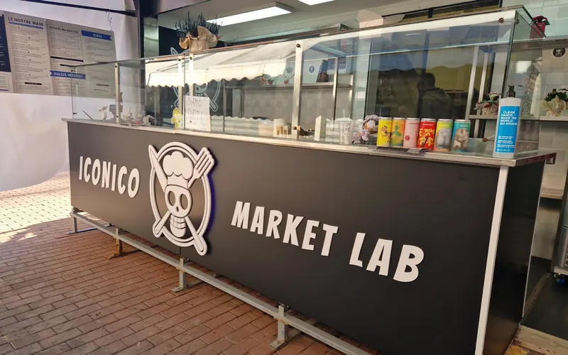 Il banco nero di ICONICO Market Lab con il teschio in cappello da cuoco, dentro il Mercato di Grottaperfetta